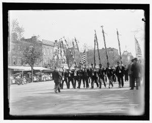 On 50th anniversary of Civil War, veterans march with flags torn in battle.