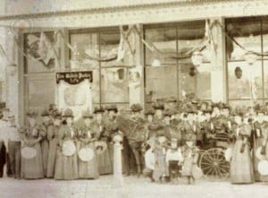 An early photo of Native Daughters under several flags.