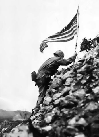 An American flag is raised over ruins of Shuri Castle