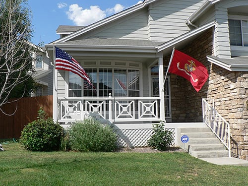 Marine Corps flag and American flag flying on the front of a house